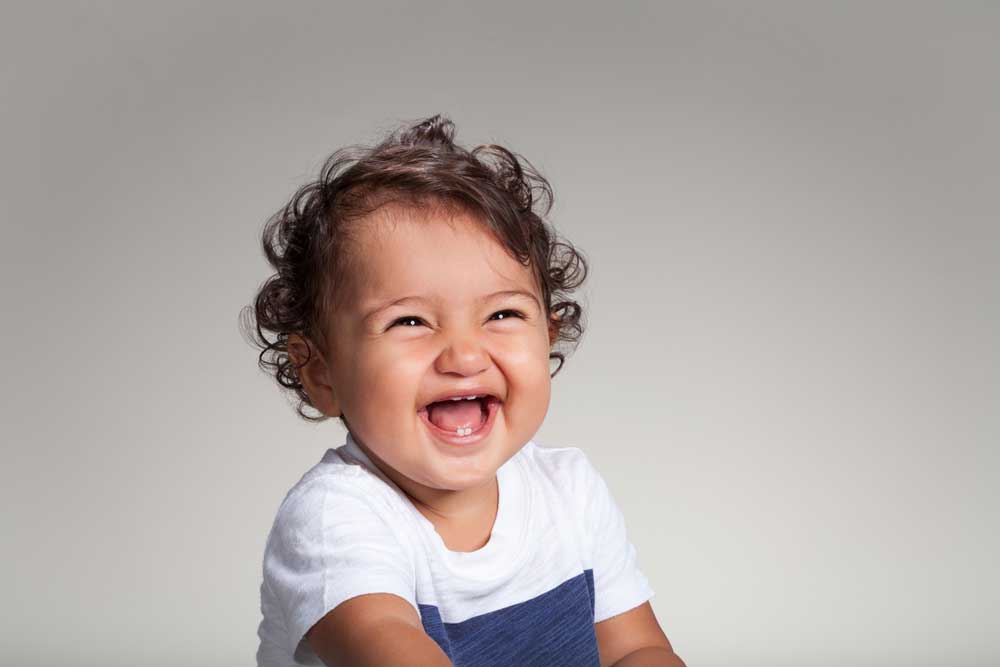 Baby with curly hair laughing