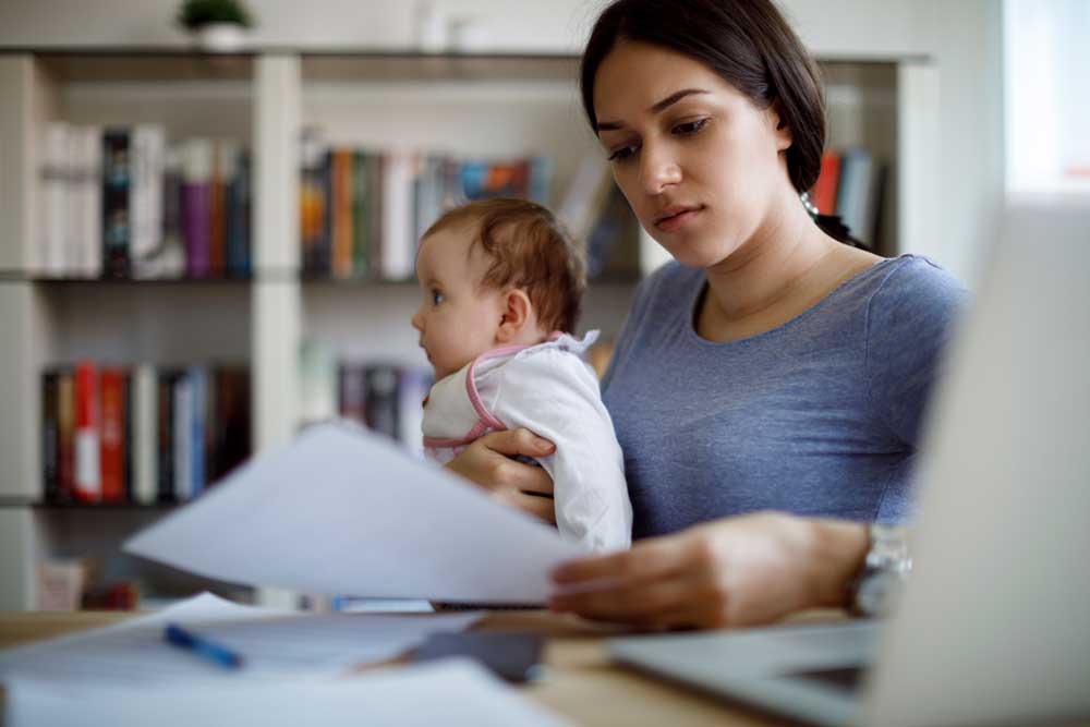 Young worried mother working from home