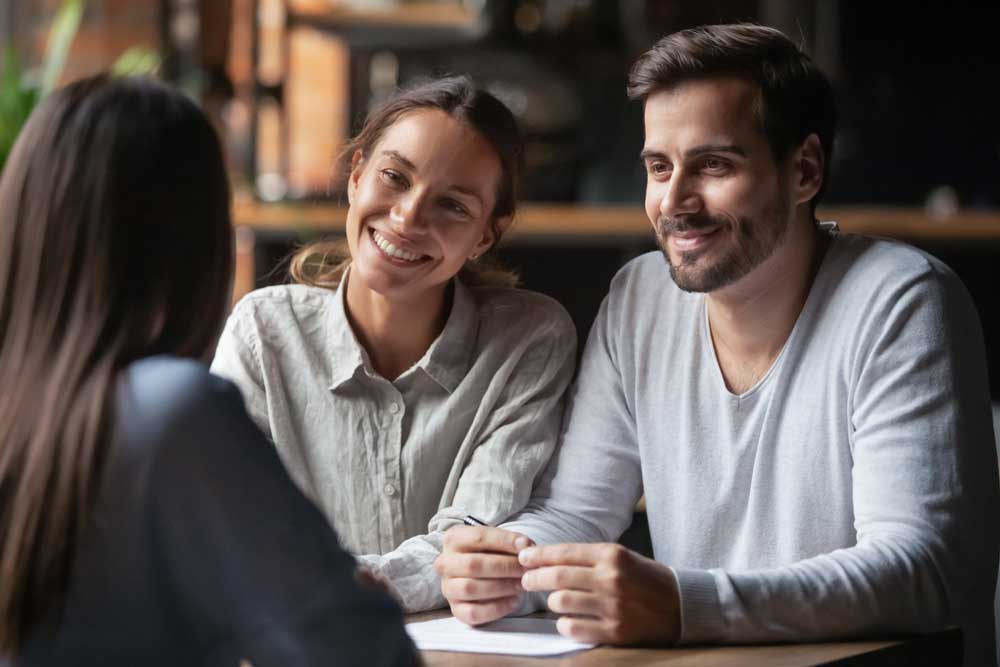 Diverse couple communicating with real estate agent, successful meeting ready to sign contract concept