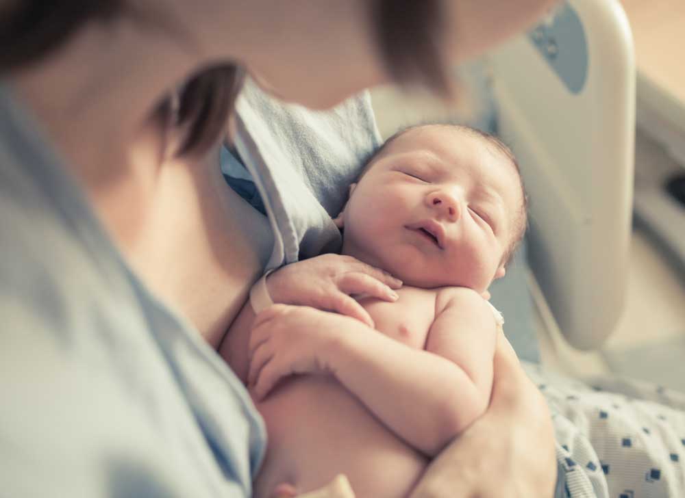 New born baby sleeping on mom 