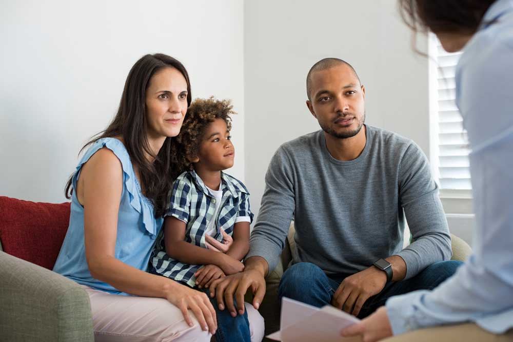 Multiethnic parents talking about adoption with their counselor.